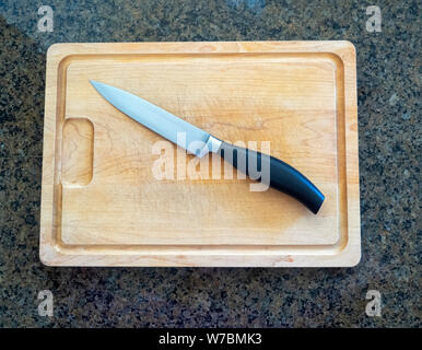 Isolato spelucchino dritto su un grande tagliere di legno con una cucina di granito contatore sfondo superiore Foto Stock