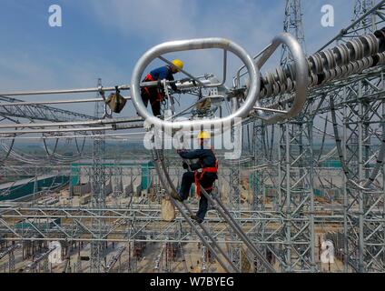 --FILE--lavoratori cinesi il lavoro presso il cantiere per la costruzione di una stazione di convertitore di Ximeng-Taizhou À800kV UHVDC (corrente continua ad alta tensione) nel progetto Foto Stock