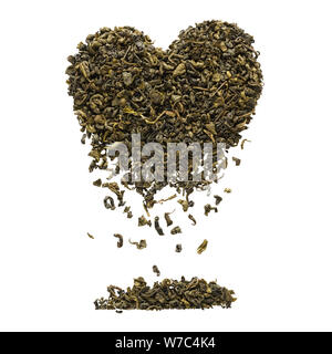 Forma di cuore fatta di estratto secco di foglie di tè oolong. Le foglie di tè che ricade verso il basso. Isolato su sfondo bianco. Foto Stock