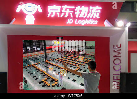 --FILE--un visitatore viene visto allo stand di JD Logistica cinese del rivenditore online JD.com durante una mostra nella città di Shenzhen, nel sud della Cina di Guangdon Foto Stock