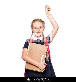 Allegro 8 anni schoolgirl con zaino indossano uniformi isolato permanente su sfondo bianco. Pronti per la scuola Foto Stock