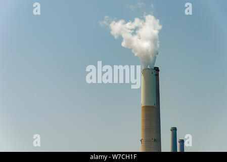 Il tubo da cui il fumo va contro il cielo grigio. Foto Stock