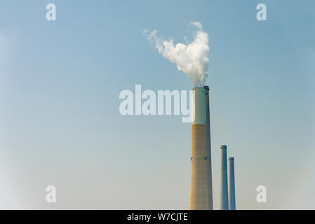 Il tubo da cui il fumo va contro il cielo grigio. Foto Stock