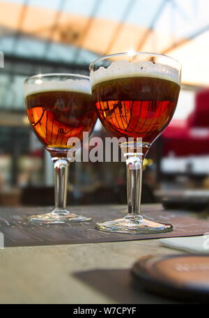 Luce di sfocatura dello sfondo con due di birra scura bicchieri sul tavolo del bar Foto Stock