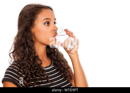 Giovane bella ragazza africana acqua potabile da un vetro su sfondo bianco Foto Stock