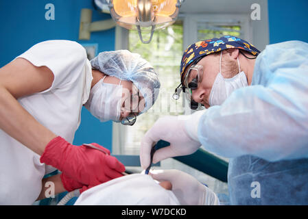 I medici di eseguire una operazione in una clinica dentale. Foto Stock