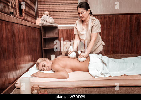 Donna ottenendo il suo Massaggio con sacchetti speciali. Foto Stock