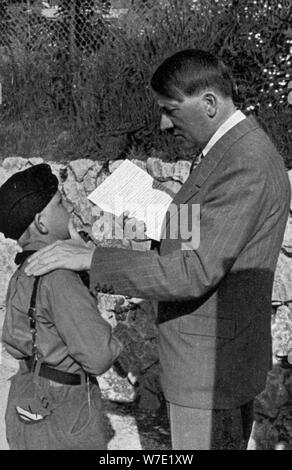 Un giovane ragazzo dalla Gioventù Hitleriana mostra Adolf Hitler una lettera da sua madre malata, 1936. Artista: sconosciuto Foto Stock