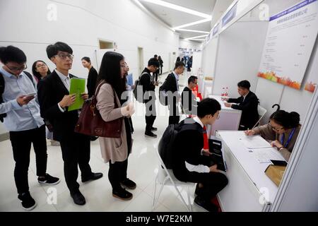 Il Cinese in cerca di lavoro parla con intervistatori in cerca di occupazione nel settore finanziario a una fiera del lavoro in Cina a Shanghai, 16 ottobre 2017. Un recente su Foto Stock