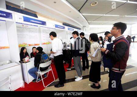 Il Cinese in cerca di lavoro parla con intervistatori in cerca di occupazione nel settore finanziario a una fiera del lavoro in Cina a Shanghai, 16 ottobre 2017. Un recente su Foto Stock