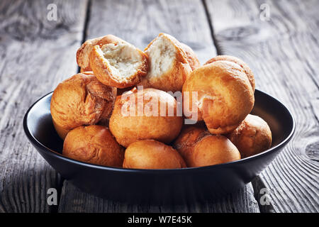 Caraibi gnocco fritto in una ciotola nero su un vecchio rustico in legno tabella, close-up Foto Stock