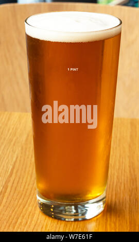 Una pinta di birra fresca di più grandi in un vetro sottile Foto Stock