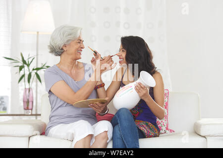 Vecchia donna con la sua nipote dipinti l'uno sull'altro faccia Foto Stock