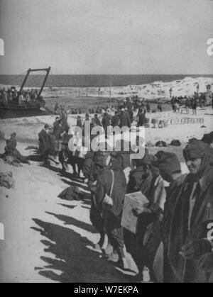 Italian prigionieri catturati dagli inglesi che assistono al caricamento di un negozio nave, 1941. Artista: sconosciuto. Foto Stock