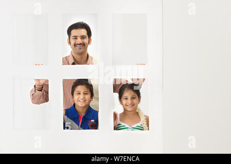 L'uomo spiata dietro una porta con i suoi figli Foto Stock