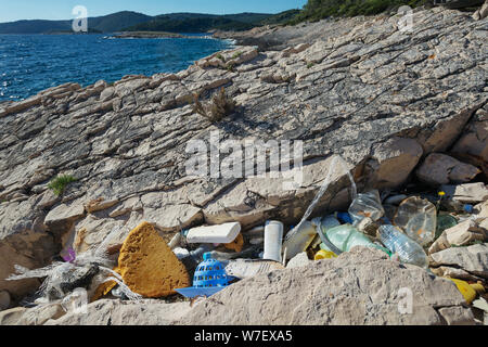 Marine i detriti si accumulano fortemente lungo le spiagge. Bottiglie di plastica e di altri rifiuti lavato fuori sulla costa. Rifiuti di plastica di marea, di inquinamento del mare. Foto Stock