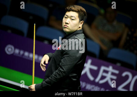 Yan Bingtao di Cina ritiene che un colpo di Alfie onere di Inghilterra nel heldover corrispondere durante il 2019 World Snooker Championship internazionale nella città di Daqing, a nord-est della Cina di Provincia di Heilongjiang, 4 agosto 2019. Yan Bingtao sconfitto onere Alfie 6-1. Foto Stock