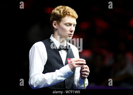 Simon Lichtenberg della Germania i gessi spunto come egli ritiene che un colpo di Ding Junhui della Cina nel heldover corrispondere durante il 2019 World Snooker Championship internazionale nella città di Daqing, a nord-est della Cina di Provincia di Heilongjiang, 4 agosto 2019. Ding Junhui sconfitto Simon Lichtenberg 6-5. Foto Stock