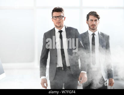 I giovani uomini di affari in un ufficio affumicato Foto Stock