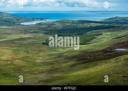 Vista sulla valle dalla sommità di Conor Pass verso Brandon Bay sulla penisola di Dingle, nella contea di Kerry, Repubblica di Irlanda Foto Stock