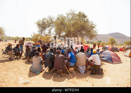 Herero e Himba uomini in un gruppo di discussione a un funerale raccolta, Kaokoland, Namibia Foto Stock