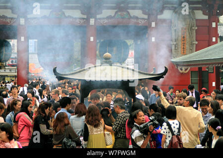 Tokyo, Giappone - 17 Giugno 2019: le persone si radunano intorno all'incenso a Sensō-ji il Tempio di Asakusa, Tokyo. Visitatori credere che il fumo di incenso Foto Stock