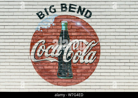 Una vecchia azienda segno appare sulla parete di una Coca-Cola impianto di imbottigliamento al di fuori di regioni alpine, Texas Foto Stock