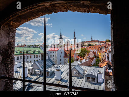 Incorniciato cityscape vista di Tallinn, Estonia guardando attraverso la medievale torre in pietra e legno finestra Foto Stock