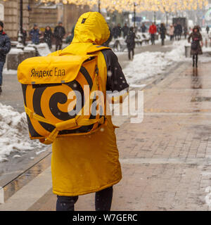 Mosca, Russia - FEBBRAIO 13,2019: un uomo dal servizio di consegna di generi alimentari - Yandex Eda, per le strade della città. In attesa di corriere per ordinare del cibo delive Foto Stock