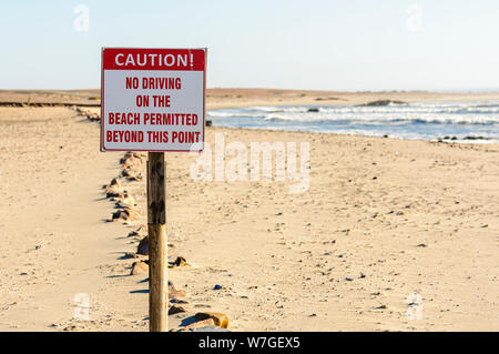 Cartello che diceva "Attenzione! Nessuna guida sulla spiaggia consentito al di là di questo punto', Cape Cross, Namibia Foto Stock