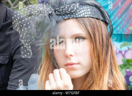 Giovane donna con minnow occhi e colleghi in un ambiente molto elegante vestito in un boho chic picnic vintage, era bello con una steampunk hat, steampunk Foto Stock