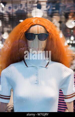 Manichini con moderni vestiti nel negozio di moda nella finestra di visualizzazione. Foto Stock