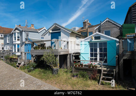 Weatherboard tradizionali case e capanne lungo la spiaggia a Whitstable, Kent, Regno Unito Foto Stock