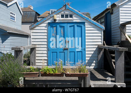 Weatherboard tradizionali case e capanne lungo la spiaggia a Whitstable, Kent, Regno Unito Foto Stock