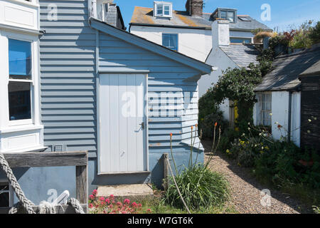 Weatherboard tradizionali case e capanne lungo la spiaggia a Whitstable, Kent, Regno Unito Foto Stock