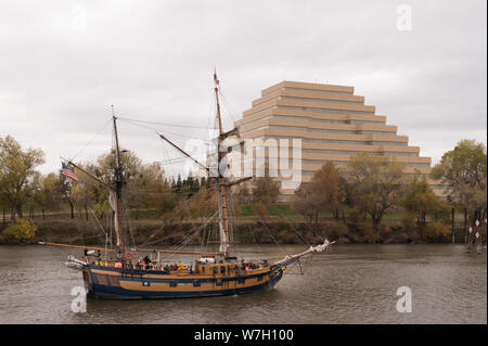 Barca sul fiume con Ziggurat edificio per uffici in background. Situato a Sacramento, la città capitale della condizione degli Stati Uniti della California e la sede della contea di Sacramento County Foto Stock