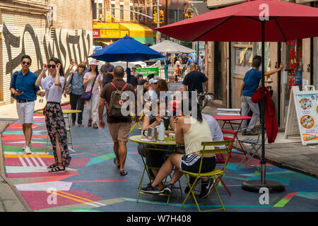 I visitatori di Doyers Street a Chinatown in New York Sabato, 3 agosto 2019 godetevi il "Asphalt Art" Con Moncho1929 come parte di Chinatown strade stagionale programma. La copertina è parte del partenariato di Chinatown's sforzi per girare la stretta, pittoresca strada in una zona pedonale. (© Richard B. Levine) Foto Stock