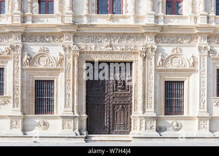 Un vecchio edificio in pietra nella città di Siviglia Spagna ornato di sculture in marmo e legno vecchio porte scolpite. Foto Stock