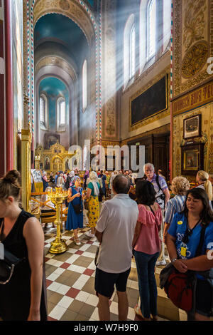 Raggi di sole che risplende nelle attraverso la finestra della chiesa sui fedeli in preghiera nell'Russioan cattedrale ortodossa a Tallinn in Estonia il 21 Luglio 2019 Foto Stock