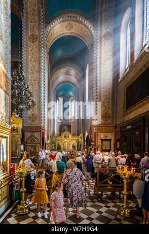Raggi di sole che risplende nelle attraverso la finestra della chiesa sui fedeli in preghiera nell'Russioan cattedrale ortodossa a Tallinn in Estonia il 21 Luglio 2019 Foto Stock