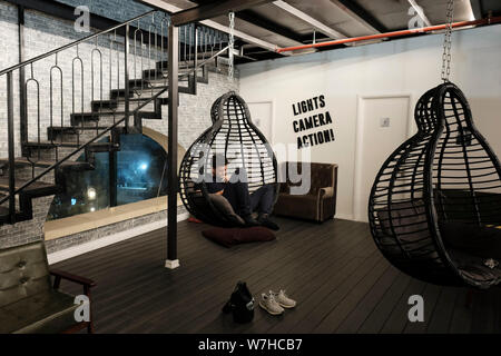 Un giovane turista seduto presso la lobby del Cinema Hostel si trova nel centro di Gerusalemme ovest Israele Foto Stock