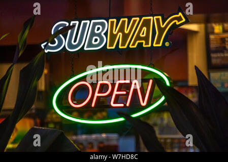 Il Neon 'aperto' segno nella finestra di una metropolitana fast food sandwich shop ristorante a West Palm Beach, Florida. (USA) Foto Stock