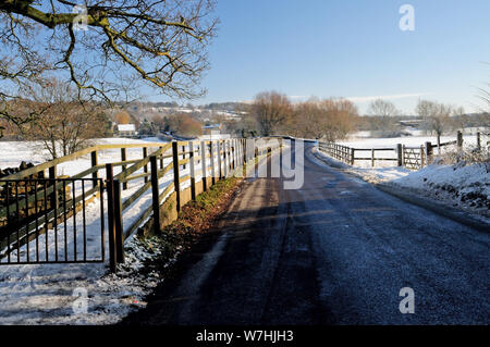 Passaggio pedonale e stradale attraverso la coperta di neve fiume Avon floodplain a Lacock, Wiltshire. Foto Stock