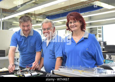 Il lavoro di squadra in un moodern fabbrica industriale - gruppo dei lavoratori nella produzione e sviluppo di elettronica Foto Stock