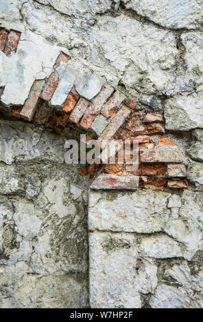 Parte della vecchia pietra grigia con parete sparsi in mattoni di colore arancione sull'arch. Foto Stock