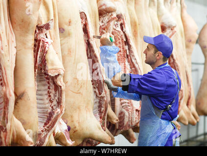 Butcher il taglio di carne di maiale alla produzione di carne Foto Stock