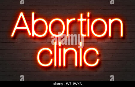 Clinica di aborto insegna al neon sul muro di mattoni in background Foto Stock