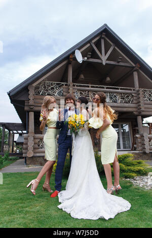 Groomsmen e damigelle con appena sposati sulla cerimonia di nozze Foto Stock