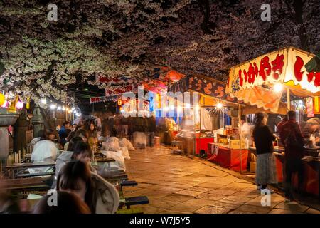 Stand gastronomici con il cibo giapponese di notte, la fioritura dei ciliegi in Primavera, Hanami Fest, il Parco Ueno Taito City, Tokyo, Giappone Foto Stock