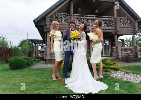 Groomsmen e damigelle con appena sposati sulla cerimonia di nozze Foto Stock